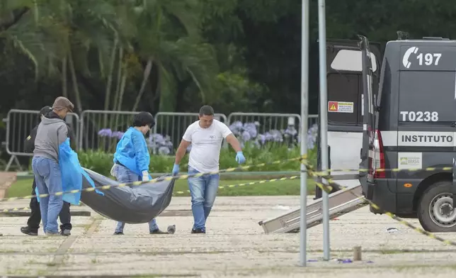 Forensic officers collect a body outside the Supreme Court following an explosion the previous night in Brasilia, Brazil, Thursday, Nov. 14, 2024. (AP Photo/Eraldo Peres)