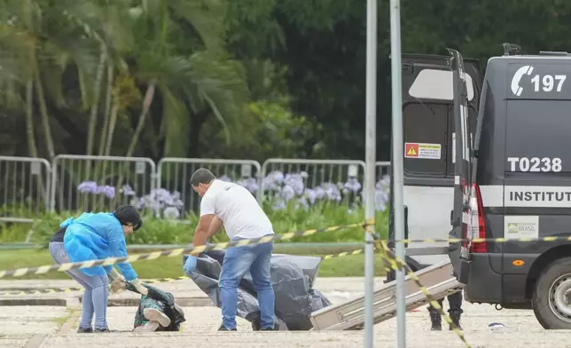 Forensic officers collect a body outside the Supreme Court following an explosion the previous night in Brasilia, Brazil, Thursday, Nov. 14, 2024. (AP Photo/Eraldo Peres)