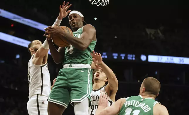 Boston Celtics' Jrue Holiday grabs a rebound in the first half of an NBA basketball game against the Brooklyn Nets, Wednesday, Nov. 13, 2024, in New York. (AP Photo/Heather Khalifa)