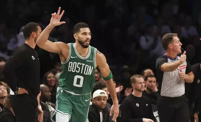 Boston Celtics' Jayson Tatum reacts after scoring a three-point basket in the first half of an NBA basketball game against the Brooklyn Nets, Wednesday, Nov. 13, 2024, in New York. (AP Photo/Heather Khalifa)