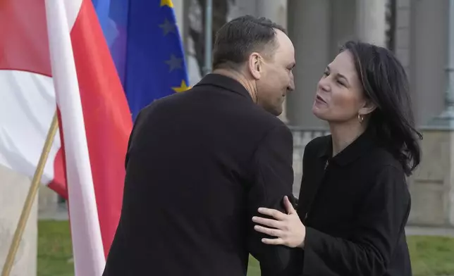 Germany's Foreign Minister Annalena Baerbock, right, is greeted by Poland's Foreign Minister Radoslaw Sikorski, upon her arrival for a meeting of European foreign ministers, in Warsaw, Tuesday, Nov. 19, 2024. (AP Photo/Czarek Sokolowski)