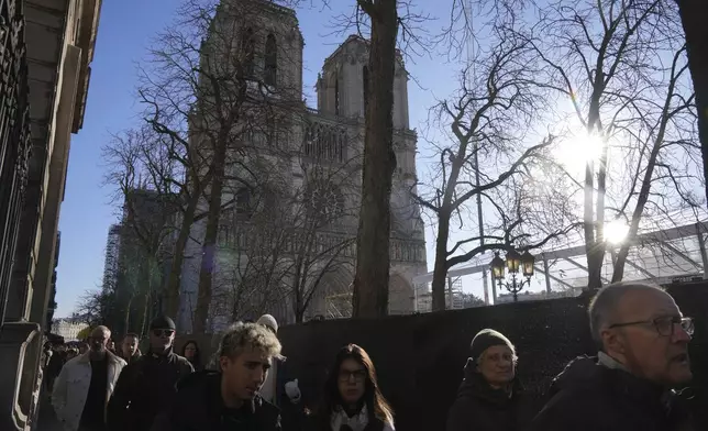 People walk by a security perimeter next to Notre-Dame cathedral, Thursday, Nov. 28, 2024 in Paris. (AP Photo/Michel Euler)