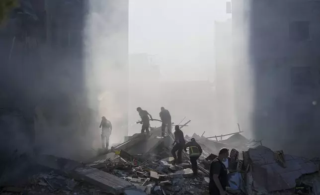 FILE - Civil defense workers extinguish a fire as smoke rises from the site of an Israeli airstrike in Tayouneh, Beirut, Lebanon, on Nov. 15, 2024. (AP Photo/Hassan Ammar, File)