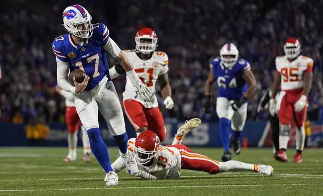 Buffalo Bills quarterback Josh Allen (17) slips past Kansas City Chiefs cornerback Nazeeh Johnson (13) to score on a 26-yard run during the second half of an NFL football game Sunday, Nov. 17, 2024, in Orchard Park, N.Y. (AP Photo/Julia Demaree Nikhinson)