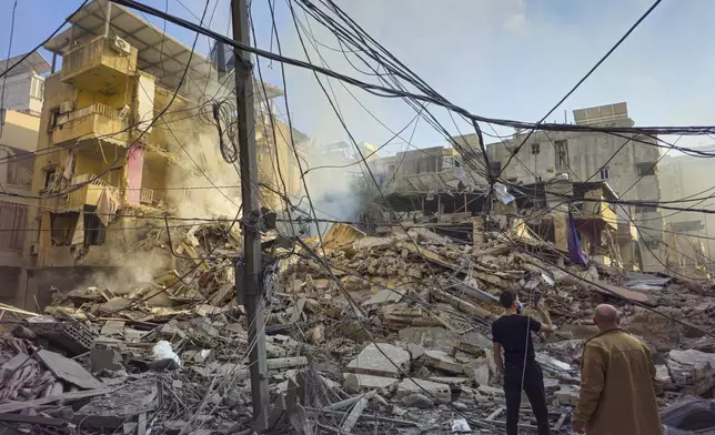 Residents check the site of an Israeli airstrike in Dahiyeh, Beirut, Lebanon, Wednesday, Nov. 13, 2024. (AP Photo/Hassan Ammar)