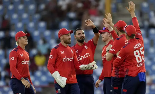 England's Saqib Mahmood celebrates with teammates taking the wicket of West Indies' Roston Chase during the third T20 cricket match at Daren Sammy National Cricket Stadium in Gros Islet, St.Lucia, Thursday, Nov. 14, 2024. (AP Photo/Ricardo Mazalan)