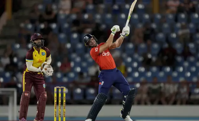 England's captain Jos Buttler plays a shot to be caught by West Indies' captain Rovman Powell during the third T20 cricket match at Daren Sammy National Cricket Stadium in Gros Islet, St. Lucia, Thursday, Nov. 14, 2024. (AP Photo/Ricardo Mazalan)