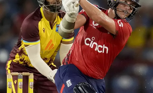 England's Sam Curran plays a shot for six runs from a delivery of West Indies' Gudakesh Motie during the third T20 cricket match at Daren Sammy National Cricket Stadium in Gros Islet, St. Lucia, Thursday, Nov. 14, 2024. (AP Photo/Ricardo Mazalan)