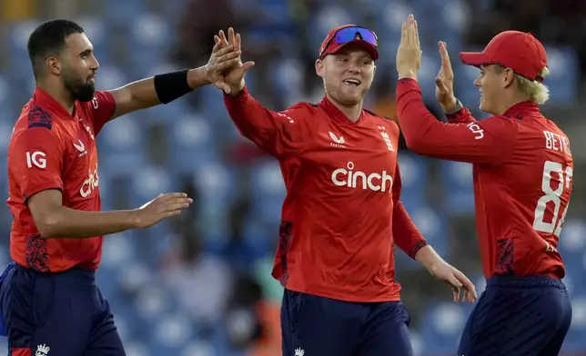 England's Saqib Mahmood, left, celebrates with teammates taking the wicket of West Indies' Roston Chase during the third T20 cricket match at Daren Sammy National Cricket Stadium in Gros Islet, St.Lucia, Thursday, Nov. 14, 2024. (AP Photo/Ricardo Mazalan)