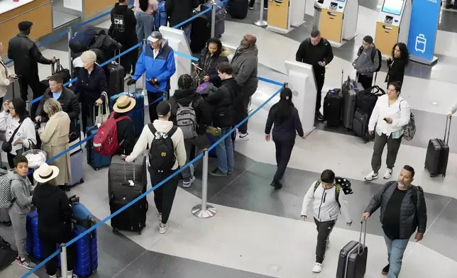 Travelers wait to drop off their bags and walk through Terminal 3 at O'Hare International Airport in Chicago, Tuesday, Nov. 26, 2024. (AP Photo/Nam Y. Huh)