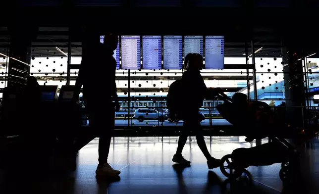 Travelers walk through Terminal 3 at O'Hare International Airport in Chicago, Tuesday, Nov. 26, 2024. (AP Photo/Nam Y. Huh)