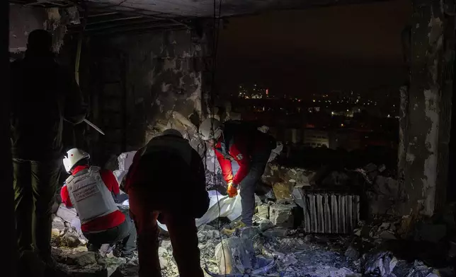 A medical emergency team collects the body of a victim who died after the Russian attack in Kyiv, Ukraine, Friday, Oct. 26, 2024. (AP Photo/Alex Babenko)