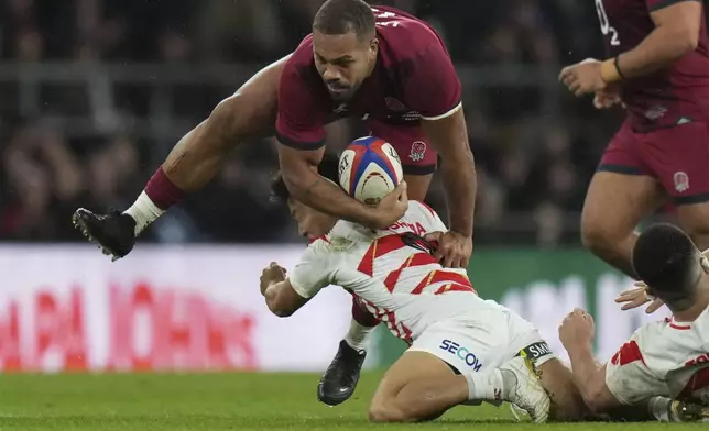 England's Ollie Lawrence is tackled by Japan's Naoto Saito during the Autumn Nations Series rugby union match between England and Japan at the Allianz Stadium Twickenham in London, Sunday, Nov. 24, 2024. (AP Photo/Alastair Grant)