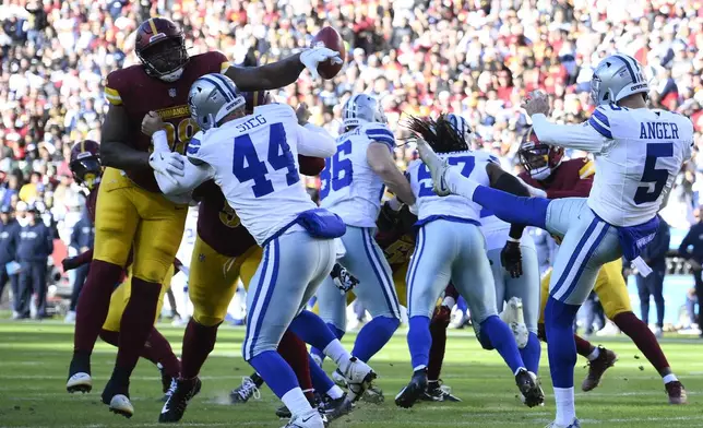 Washington Commanders defensive tackle Phidarian Mathis (98) blocks a punt by Dallas Cowboys punter Bryan Anger (5) during the first half of an NFL football game, Sunday, Nov. 24, 2024, in Landover, Md. (AP Photo/Nick Wass)