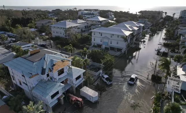 FILE - A truck drives down a flooded street in Siesta Key, Fla., following the passage of Hurricane Milton, on Oct. 10, 2024. (AP Photo/Rebecca Blackwell, File)