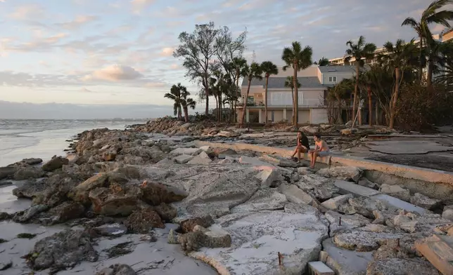 FILE - Young people from Sarasota, Fla., visit a beach on Siesta Key, Fla., on Oct. 10, 2024. The beach was damaged by Hurricane Helene and Hurricane Milton. (AP Photo/Rebecca Blackwell, File)