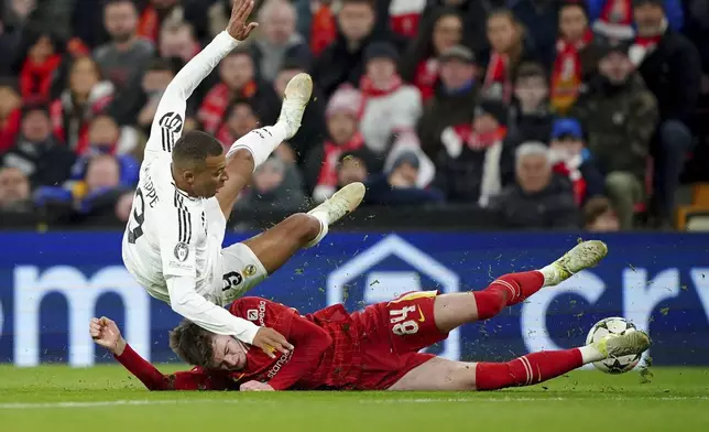 Liverpool's Conor Bradley tackles Real Madrid's Kylian Mbappe during the Champions League opening phase soccer match between Liverpool and Real Madrid at Anfield Stadium, Liverpool, England, Wednesday, Nov. 27, 2024. (Peter Byrne/PA via AP)