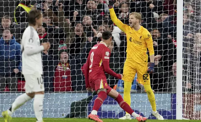 Liverpool's goalkeeper Caoimhin Kelleher celebrates after stopping a penalty shot from Real Madrid's Kylian Mbappe during the Champions League opening phase soccer match between Liverpool and Real Madrid at Anfield Stadium, Liverpool, England, Wednesday, Nov. 27, 2024. (AP Photo/Jon Super)