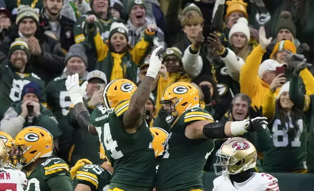 Green Bay Packers guard Elgton Jenkins, left, and Green Bay Packers center Josh Myers, right, celebrate a touchdown during the first half of an NFL football game against the San Francisco 49ers on Sunday, Nov. 24, 2024 in Green Bay, Wis. (AP Photo/Morry Gash)