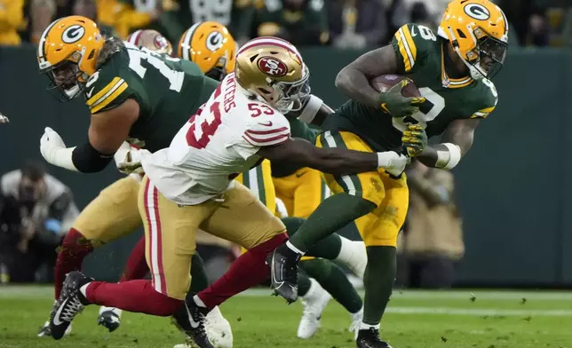 Green Bay Packers running back Josh Jacobs (8) runs against San Francisco 49ers linebacker Dee Winters (53) during the first half of an NFL football on Sunday, Nov. 24, 2024 in Green Bay, Wis. (AP Photo/Morry Gash)