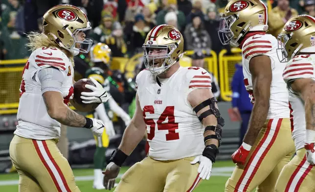 San Francisco 49ers tight end George Kittle (85) celebrates a touchdown with teammates during the first half of an NFL football game against the Green Bay Packers on Sunday, Nov. 24, 2024 in Green Bay, Wis. (AP Photo/Mike Roemer)