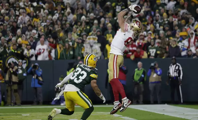 San Francisco 49ers tight end George Kittle (85) makes a touchdown catch against Green Bay Packers safety Evan Williams (33) during the first half of an NFL football game on Sunday, Nov. 24, 2024 in Green Bay, Wis. (AP Photo/Matt Ludtke)