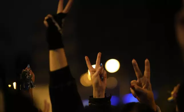 People gesture as thousands of protesters gather to mark the 35th anniversary of the Velvet Revolution, that brought an end to decades of communist rule in Czechoslovakia, and to oppose the policies of populist Prime Minister Robert Fico, in Bratislava, Slovakia, Sunday, Nov. 17, 2024. (AP Photo/Petr David Josek)