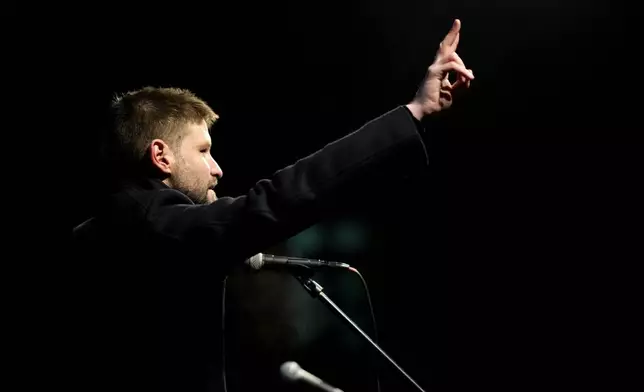 Leader of Progressive Slovakia party Michal Simecka gestures as thousands of protesters gather to mark the 35th anniversary of the Velvet Revolution, that brought an end to decades of communist rule in Czechoslovakia, and to oppose the policies of populist Prime Minister Robert Fico, in Bratislava, Slovakia, Sunday, Nov. 17, 2024. (AP Photo/Petr David Josek)