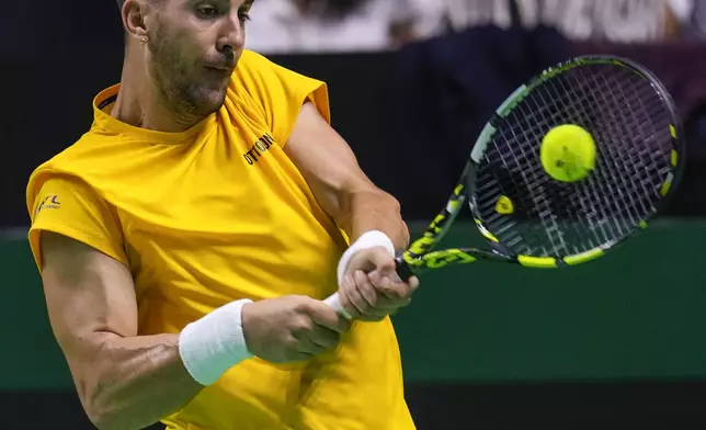 Australia's Thanasi Kokkinakis returns the ball against Italy's Matteo Berrettini during the Davis Cup semifinal at the Martin Carpena Sports Hall in Malaga, southern Spain, on Saturday, Nov. 23, 2024. (AP Photo/Manu Fernandez)