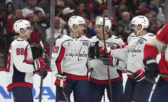 Washington Capitals center Lars Eller (20) is congratulated after scoring during the first period of an NHL hockey game against the Florida Panthers, Monday, Nov. 25, 2024, in Sunrise, Fla. (AP Photo/Lynne Sladky)