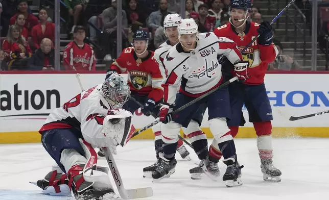 Washington Capitals goaltender Logan Thompson, left defends the goal during the second period of an NHL hockey game against the Florida Panthers, Monday, Nov. 25, 2024, in Sunrise, Fla. (AP Photo/Lynne Sladky)