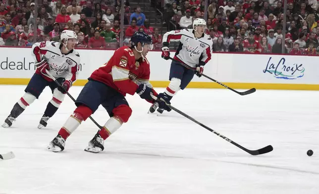 Florida Panthers center Carter Verhaeghe (23) and Washington Capitals defenseman Rasmus Sandin (38) chase the puck during the second period of an NHL hockey game, Monday, Nov. 25, 2024, in Sunrise, Fla. (AP Photo/Lynne Sladky)