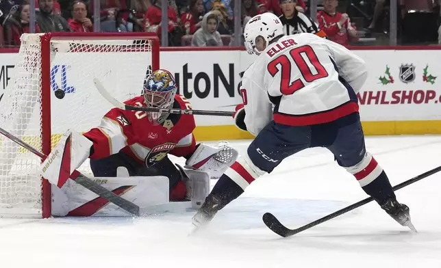 Washington Capitals center Lars Eller (20) scores past Florida Panthers goaltender Spencer Knight, left, during the first period of an NHL hockey game, Monday, Nov. 25, 2024, in Sunrise, Fla. (AP Photo/Lynne Sladky)