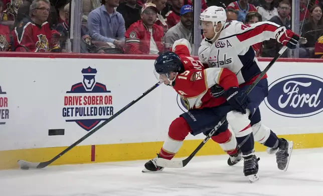 Florida Panthers left wing Matthew Tkachuk, left, goes for the puck as Washington Capitals defenseman John Carlson, right, defends during the second period of an NHL hockey game, Monday, Nov. 25, 2024, in Sunrise, Fla. (AP Photo/Lynne Sladky)