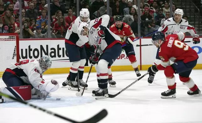 Washington Capitals goaltender Logan Thompson, left, defends the goal against Florida Panthers center Sam Bennett (9) during the second period of an NHL hockey game, Monday, Nov. 25, 2024, in Sunrise, Fla. (AP Photo/Lynne Sladky)