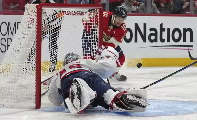 Washington Capitals goaltender Logan Thompson, left, makes a save against Florida Panthers center Aleksander Barkov (16) during the second period of an NHL hockey game, Monday, Nov. 25, 2024, in Sunrise, Fla. (AP Photo/Lynne Sladky)