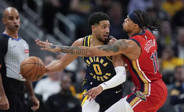 Indiana Pacers' Tyrese Haliburton (0) makes a pass against New Orleans Pelicans' Brandon Boston Jr. (11) during the second half of an NBA basketball game, Monday, Nov. 25, 2024, in Indianapolis. (AP Photo/Darron Cummings)