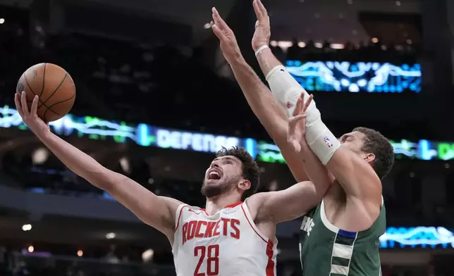 Houston Rockets' Alperen Sengun shoots past Milwaukee Bucks' Brook Lopez during the second half of an NBA basketball game Monday, Nov. 18, 2024, in Milwaukee. The Bucks won 101-100. (AP Photo/Morry Gash)