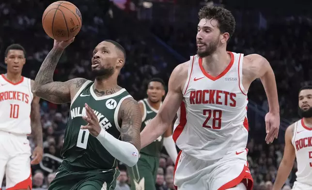 Milwaukee Bucks' Damian Lillard drives past Houston Rockets' Alperen Sengun during the first half of an NBA basketball game Monday, Nov. 18, 2024, in Milwaukee. (AP Photo/Morry Gash)