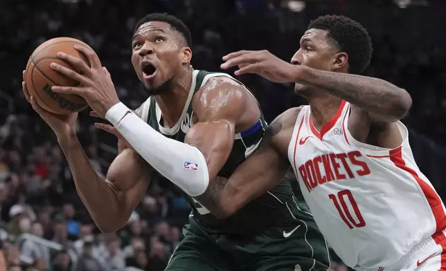 Milwaukee Bucks' Giannis Antetokounmpo tries to get past Houston Rockets' Jabari Smith Jr. during the first half of an NBA basketball game Monday, Nov. 18, 2024, in Milwaukee. (AP Photo/Morry Gash)