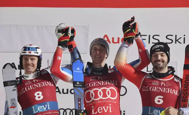 From left, second placed Norway's Henrik Kristoffersen, the winner France's Clement Noel and third placed Switzerland's Loic Meillard celebrate on podium after an alpine ski, men's World Cup slalom, in Levi, Finland, Sunday, Nov. 17, 2024. (AP Photo/Marco Trovati)