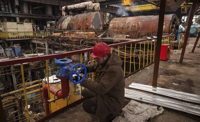 A worker repairs equipment at DTEK's power plant after a recent Russian missile attack in Ukraine, Nov. 28, 2024. (AP Photo/Evgeniy Maloletka)