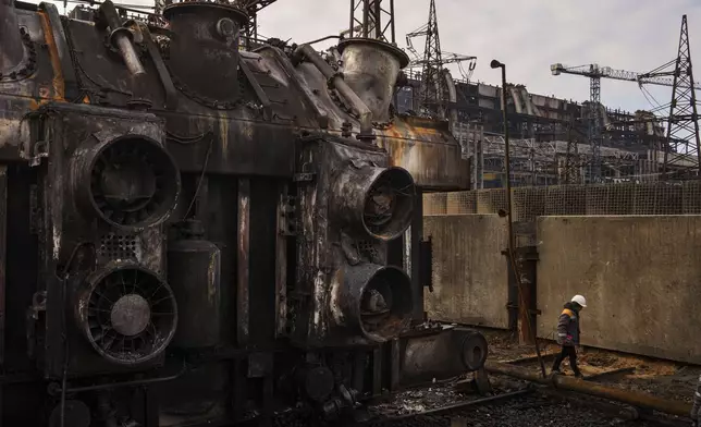 A worker walks in front of a transformer which was destroyed after a recent Russian missile attack at DTEK's power plant in Ukraine, Nov. 28, 2024. (AP Photo/Evgeniy Maloletka)