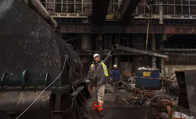 A worker lowers a metal bar to the ground using a crane during repairs to DTEK's power plant after a recent Russian missile attack in Ukraine, Nov. 28, 2024. (AP Photo/Evgeniy Maloletka)