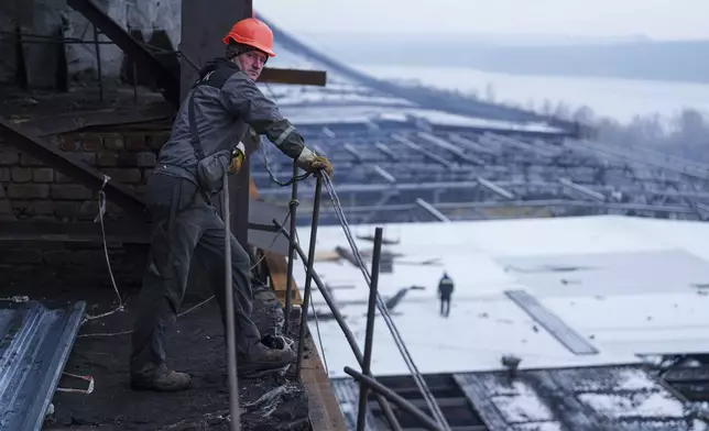 A worker stands on a roof of a DTEK's power plant after a recent Russian missile attack in Ukraine, Nov. 28, 2024. (AP Photo/Evgeniy Maloletka)