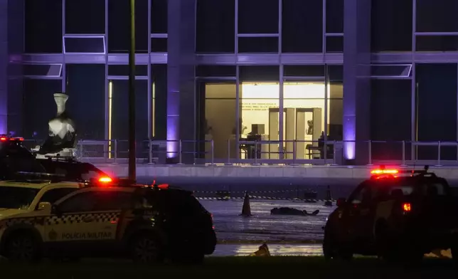 A body lies outside the Supreme Court in Brasília, Brazil, following an explosion, Wednesday, Nov. 13, 2024. (AP Photo/Eraldo Peres)