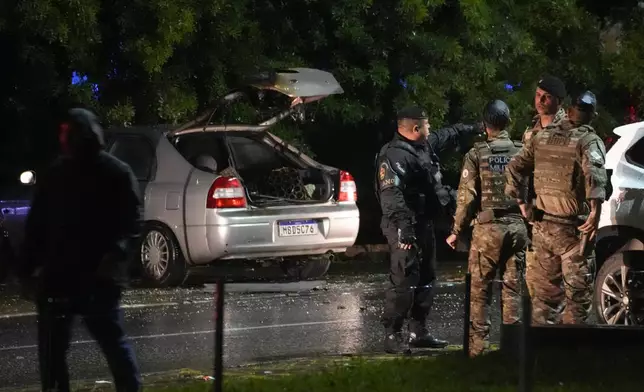 Police inspect a vehicle outside the Supreme Court in Brasília, Brazil, following an explosion, Wednesday, Nov. 13, 2024. (AP Photo/Eraldo Peres)