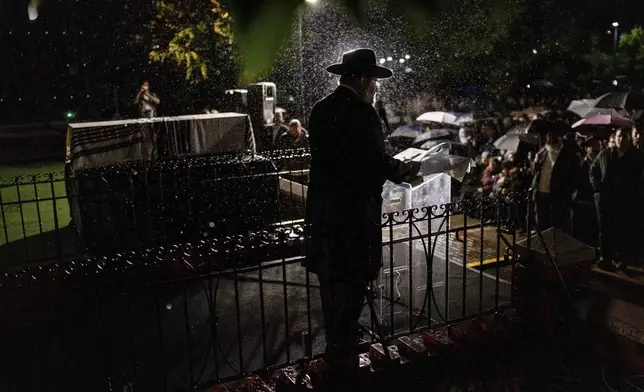 A rabbi delivers a eulogy next to the coffin containing the remains of Israeli-Moldovan rabbi Zvi Kogan in Kfar Chabad, Israel, Monday Nov. 25, 2024. Kogan, 28, an ultra-Orthodox rabbi, was killed last week in Dubai where he ran a kosher grocery store. (AP Photo/Ohad Zwigenberg)