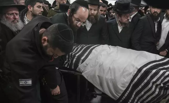 The body of Israeli-Moldovan rabbi Zvi Kogan is carried into a funeral home before his burial in Jerusalem, Monday Nov. 25, 2024. Kogan, 28, an ultra-Orthodox rabbi, was killed last week in Dubai where he ran a kosher grocery store. Israelis have flocked for commerce and tourism since the two countries forged diplomatic ties in the 2020 Abraham Accords.(AP Photo/Mahmoud Illean)