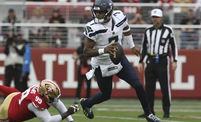 Seattle Seahawks quarterback Geno Smith (7) rolls out in front of San Francisco 49ers defensive tackle Maliek Collins (99) during the second half of an NFL football game in Santa Clara, Calif., Sunday, Nov. 17, 2024. (AP Photo/Jed Jacobsohn)